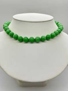 Green Jade Jadeite Bead Necklace.  This hand knotted necklace features 32 Green Jade Jadeite Beads Round Polished Grade AAA 11.9 to 12.4mm.  I hand knotted these with green silk thread and finished them with a 925 Silver Fold Over Magnetic Clasp.  The necklace measures 18 inches in length.  Please keep in mind that large beads take up space on the neck and they will fit tighter than an 18 inch chain.  The Beads are Genuine and Natural in color, no treatments.  The necklace pictured is the one you will receive.   It will arrive in a nice presentation box with a Certificate of Authenticity.   Please visit our Shop for more Pearls and Gemstone Jewelry. Classic Green Jewelry With 8mm Beads, Classic Jade Necklaces With Round Beads, Classic Green Beaded Necklaces With Round Beads, Classic Jade Necklace With Round Beads, Formal Green Single Strand Beaded Necklace, Single Strand Jade Beaded Necklace With Round Beads, Green Single Strand Necklace With Round Beads, Classic Green Gemstone Beads Necklace, Elegant Single Strand Green Beads