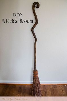 a broom sitting on top of a wooden floor in front of a wall with words that say diy witch's broom