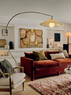 a living room filled with furniture and a large art piece hanging on the wall above it