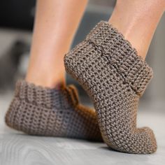 a woman's feet in crocheted slippers