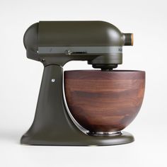 an olive green kitchen mixer with wooden bowl on the front and side, against a white background