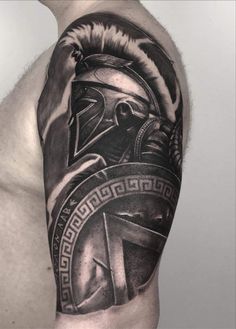 a man's arm with a spartan tattoo on it and an image of a helmet