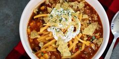 a bowl of chili with tortilla chips and sour cream