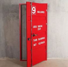 an open red door with the number nine on it in front of a concrete wall