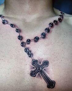 a man with a rosary and cross tattoo on his chest