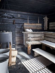 an old wooden room with benches and trash cans