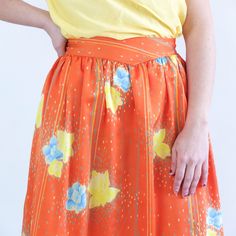 Amazing vintage 80's orange floral satin skirt with blue and yellow flowers print, dotted and pinstripe. This high waist circle skirt has retro style, it's 80's summer midi full skirt, it has yoke and side buttons and zip closure. The skirt is polyester fabric but only retains the old size label, is a used skirt and is not perfect for its age and delicate fabric, has some small loose threads and a small stain, but as its print is so striking is not much appreciated. The modern size is Small, the Summer Orange Maxi Skirt With Elastic Waistband, Flowy Orange Maxi Skirt With Elastic Waistband, Retro Floral Print Skirt For Summer, Retro Floral Print Summer Skirt, Retro Pleated Skirt For Summer, Retro Flared Skirt For Spring, Flowy Orange Skirt For Spring, Retro Orange Summer Skirt, Spring Retro Lined Skirt