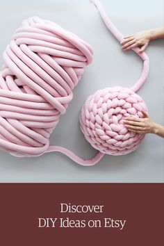 a pink ball of yarn being held by two hands