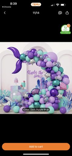 the balloon arch is decorated with purple, blue and green balloons for a mermaid themed birthday party