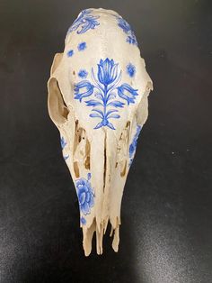 an animal skull with blue flowers painted on it