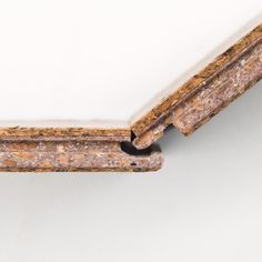 the corner of a wooden frame with white paint and brown speckles on it