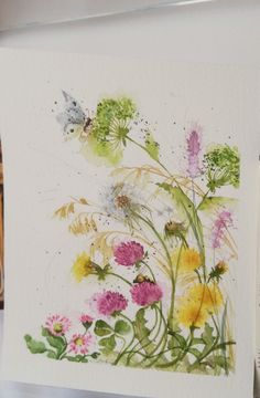 watercolor painting of flowers and butterflies on white paper with colored pencils in the background