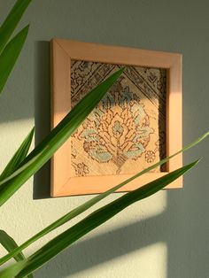 a close up of a plant near a wall with a painting on the wall behind it