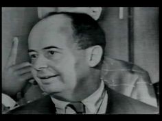 an old black and white photo of a man in a suit talking on the phone