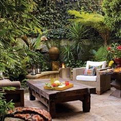 an outdoor patio with wicker furniture and potted plants in the background, surrounded by greenery