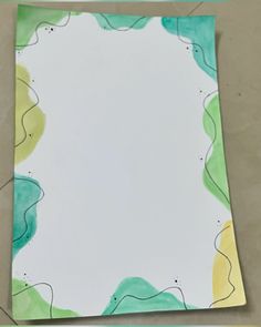 an empty piece of paper with watercolors on it and the bottom half cut off