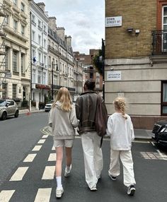 three people are walking down the street together