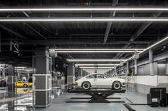 two cars are parked in a large garage