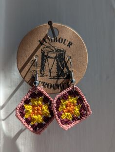 a pair of crocheted earrings hanging from a hook