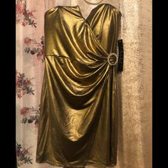 a gold dress hanging on a wall