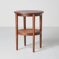 a wooden table with a wicker basket on the bottom and one shelf below it