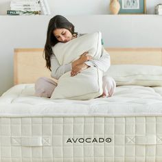 a woman sitting on top of a white mattress