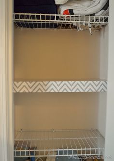 an empty closet is shown with shelves on the bottom and bottom shelf, in white