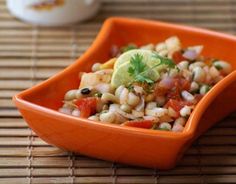 an orange bowl filled with food on top of a table