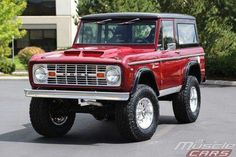 a red truck is parked in a parking lot