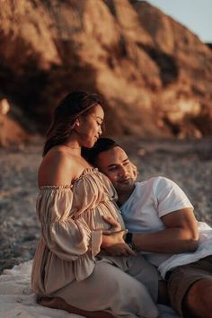 a man sitting next to a woman on the beach