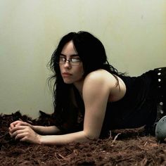 a woman laying on the ground wearing glasses