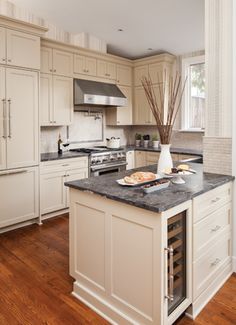 a kitchen with white cabinets and an island in the middle of the room is shown