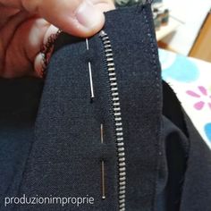 someone is stitching the zipper on a black jacket