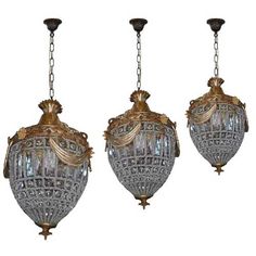 three glass and brass chandeliers hanging from chains on a white background with clippings