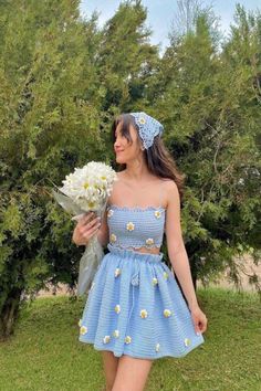 a woman in a blue dress holding flowers