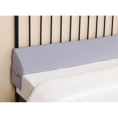 a close up of a bed with a white sheet and blue pillow on top of it