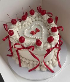 a heart shaped cake with cherries on top