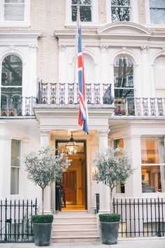 the front entrance of a hotel with an american flag hanging from it's door