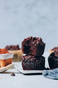 two chocolate muffins stacked on top of each other with one bite taken out