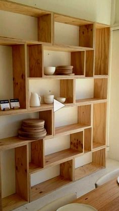 a wooden shelf filled with plates and bowls