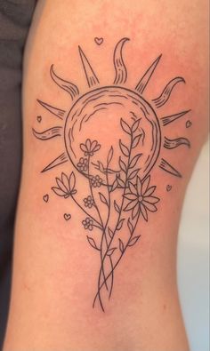 a woman's thigh with flowers and sun tattoo on it