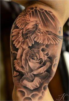 a black and white tattoo with two birds flying over a rose