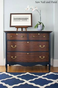 an old dresser has been painted blue and white with gold hardware on it, along with a framed art piece