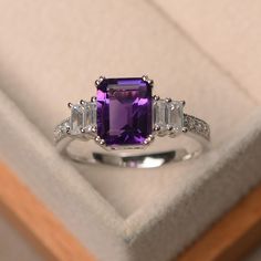 This ring features a 7*9 mm emerald cut natural amethyst and sterling silver finished with rhodium. Customization is available. It is made by hand, and it will take about 7 days to finish the ring after your payment is completed. Main stone: natural amethyst Main stone weight: Approx 2.2 ct Metal type: sterling silver finished with rhodium Accent stone: cz Customization is available, I also can make it with 14k solid gold (white or yellow or rose) and diamond accent stone, just feel free to cont Amethyst Ring Engagement, Pearl Engagement Ring, Purple Amethyst Ring, Emerald Engagement Ring Cut, Black Ring, Amethyst Jewelry, Gem Stones, Emerald Engagement Ring, 70th Birthday