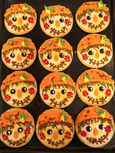 twelve decorated cookies in the shape of scare faces