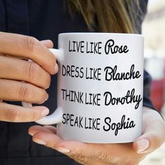 a person holding a coffee mug with words on the front and back of it in their hands