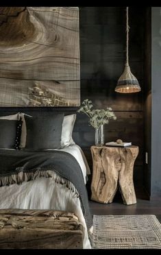 a bed room with a neatly made bed next to a wooden table and lamp hanging from the ceiling