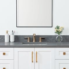 a bathroom with marble counter tops and gold faucets