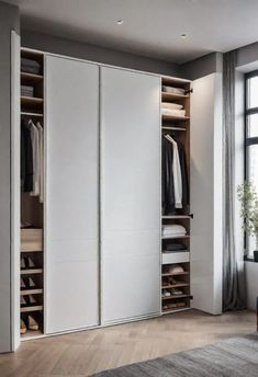 an open closet with white doors and drawers in a room next to a large window