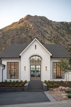 a white house with a mountain in the background